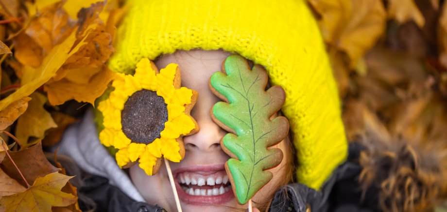 Bright autumn gingerbread in the hands of a child.